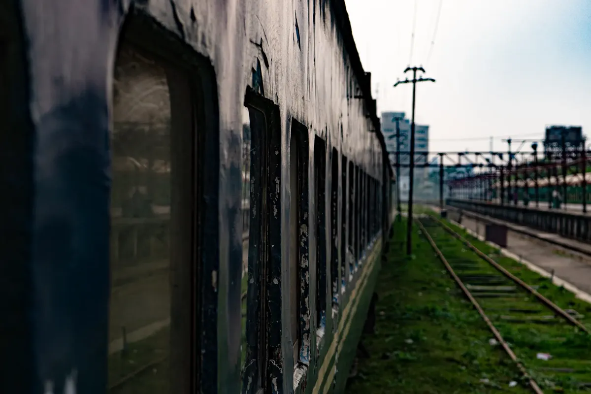 An old train carriage sits at an urban railway station, evoking nostalgia for past travels.